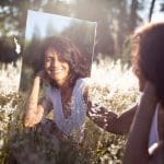 smiling woman s reflection on a mirror