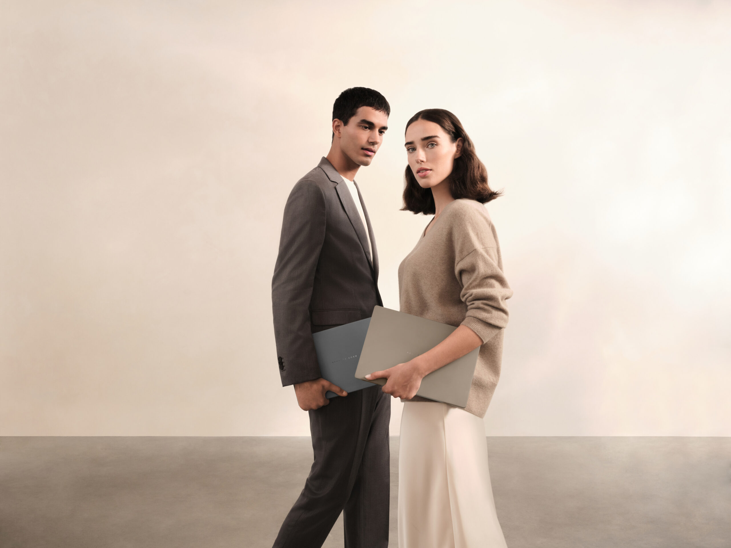 A couple holding two ASUS Zenbook A14 laptops